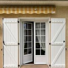 Fenêtre PVC blanche sur arc en briques, secteur de Mirande